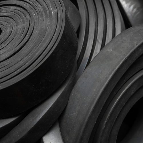 rolls-scaled.jpg Black rubber rolls stacked together - Custom Rubber & Polyurethane Manufacturing